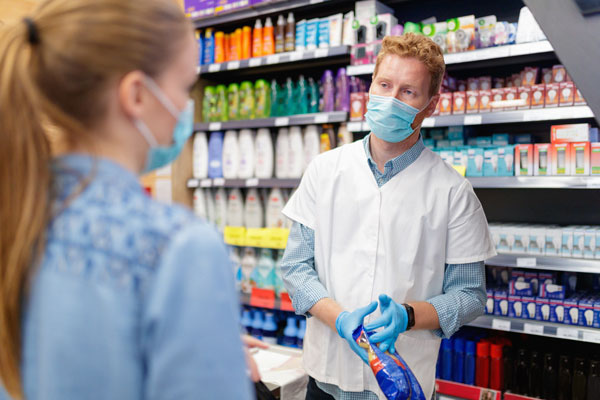 retail worker in mask listening to customer